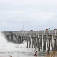 Waves break against the County Pier as beachgoers were able to visit before it was closed in the afternoon in advance of Tropical Storm Hermine Thursday in Panama City Beach, Florida. Hermine strengthened into a hurricane Thursday and steamed toward Florida's Gulf Coast, where people put up shutters, nailed plywood across store windows and braced for the first hurricane to hit the state in over a decade. 'Life-threatening' Hurricane Hermine draws bead on Florida