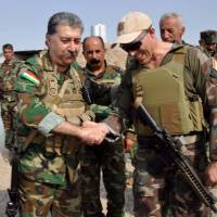 In this picture posted on his Facebook page Aug. 31, Hussein Yazdanpana, leader of the Kurdistan Freedom Party (PAK), an Iranian Kurdish armed opposition group, shakes hands with who he said was a Western military advisor. Yazdanpana told AP his group had been receiving military training from American and European advisers. U.S., Europe advisers trained Iran insurgents among Kurds in Islamic State fight