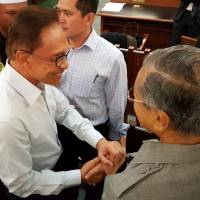 Former Malaysian Prime Minister Mahathir Mohamad (right) meets with jailed opposition leader Anwar Ibrahim at a court in Kuala Lumpur on Monday. Malaysia abuzz as old foes Mahathir, Anwar join hands