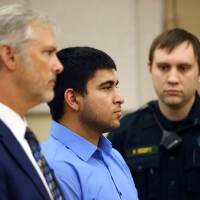 Suspect Arcan Cetin stands with his attorney and a bailiff as he appears for his arraignment on murder charges in the killing of five people, in Mt. Vernon, Washington, Monday. Accused Washington mall massacre suspect confesses to all five slayings