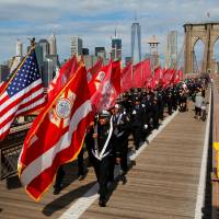 Members of Engine 219 Ladder 105 and fellow firefighters march to Brooklyn over the Brooklyn Bridge in honor of firefighters lost in the 9/11 attacks on the event's 15th anniversary in Manhattan, New York, Sunday. America remembers world-changing day on 15th anniversary of 9/11