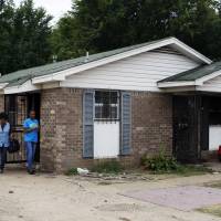 Pastor Mary Moore (left) and Janie Hendrix view a home where an early morning fire killed multiple people Monday in Memphis, Tennessee. Officials are trying to determine the cause of the fire. Memphis house fire kills nine, including five kids; one fighting for life