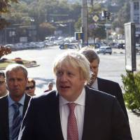 Britain's Foreign Secretary Boris Johnson walks around the city after visiting a memorial for Maidan activists killed during the 2014 anti-government protests, Thursday in Kiev. Boris Johnson favors turning migrant boats back to Libya as 'deterrent'
