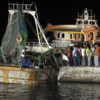 People gather on the quay as the wreck of a migrant boat raised by the Egyptian navy and maritime rescuers arrives in the Egyptian port city of Rosetta on Tuesday. The Egyptian military said 163 people had been rescued. The boat would have had at least 365 people on board when it went down en route to Italy, according to official figures. Death toll up to 202 as Egypt finds 33 more corpses while salvaging sunken migrant boat