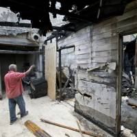 Farhad Khan, who has attended the Islamic Center of Fort Pierce for more than seven years, shows members of the media its charred remains Thursday in Fort Pierce, Florida. An ex-convict who posted anti-Islamic rants online confessed to setting fire to the mosque that the Orlando nightclub shooter occasionally attended, and said he was embarrassed by the crime, according to an arrest affidavit released Thursday. 9/11 Florida mosque arson suspect confesses