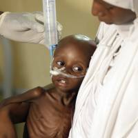 A doctor feeds a malnourished child at a feeding centre run by Doctors Without Borders in Maiduguri, Nigeria, on Aug. 29. As many as 75,000 children will die over the next year in famine-like conditions created by Boko Haram if donors don't respond quickly, the U.N. Children's Fund said. Famine could claim 75,000 children in Nigeria, U.N. warns