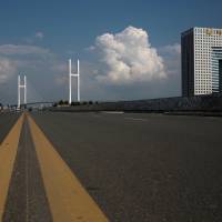 An empty street runs in front of the unfinished New Yalu River Bridge (left) and the empty Chinese customs building in Dandong, China, on Sept. 11. The bridge was designed to connect China's Dandong New Zone and North Korea's Sinuiju. 'Bridge to nowhere' shows China's failed economic effort to engage North Korea
