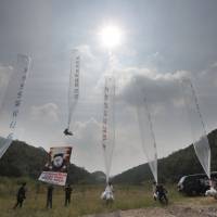 Anti-North Korea activists launch helium balloons from a field in Paju, near the demilitarized zone (DMZ) separating North and South Korea, on Thursday. North Korea ramps up uranium enrichment, enough for six nuclear bombs a year-experts
