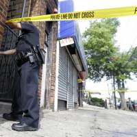 A police officer ties tape around the First American Fried Chicken restaurant Wednesday in Elizabeth, New Jersey. The Elizabeth establishment and the apartment above are tied to Ahmad Khan Rahami, who was arrested as a suspect in the weekend bombings in New York and New Jersey. Investigators looking into whether NYC bomb suspect had help