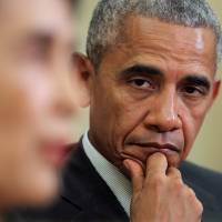 U.S. President Barack Obama listens as Myanmar's State Counselor Aung San Suu Kyi talks to the media during a bilateral meeting at the Oval Office of the White House in Washington Wednesday. Obama declares end to most Myanmar sanctions as he welcomes Suu Kyi