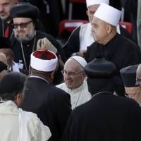 Pope Francis greets representatives of different religions, including Canterbury Archbishop Justin Welby (right), at the end of an inter-religious prayer gathering, in front of the Basilica of St. Francis in Assisi, Italy, Tuesday. Pope prays for peace with refugees, religious leaders, says there's 'no God of war'