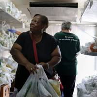 Carmelita Dorsey looks at fresh fruits and vegetables inside a refrigerator truck at Oak Forest Health Center in Oak Forest, Illinois, on Sept. 22. Six health clinics are working with the Chicago food bank to host a mobile pantry filled with fresh produce. Doctors 'prescribe' fresh produce with help from America's food banks