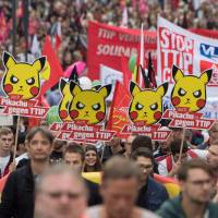 Demonstrators hold up posters reading, Pikachu, too, is against TTIP during a protest against the massive trans-Atlantic trade deals CETA and TTIP on Saturday in Frankfurt am Main, Germany. Tens of thousands protest in Europe against trans-Atlantic trade deals