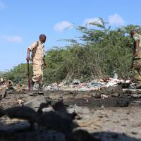 Somali soldiers inspect the scene of a suicide car bomb attack by al Shabaab in Somalia's capital Mogadishu on Sunday. Al-Shabab threatens Somalia elders with 'iron hand' over coming polls