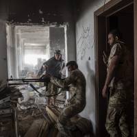 A fighter loyal to Libya's Government of National Accord fires his weapon during fighting against the Islamic State in Sirte on Thursday. Ten jihadists and nine pro-government fighters died in clashes around the last positions of the Islamic State group in the Libyan coastal city. Libyan forces foil Islamic State car bombings in Sirte, kill at least 10 jihadis