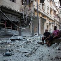 Survivors view the aftermath of an airstrike on the regime-controlled neighborhood of Karm al-Jabal on Sunday. Syrian truce receives new blows with airstrikes, shelling