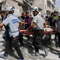 In this photo provided by the Syrian Civil Defense White Helmets, rescue workers work the site of airstrikes in the al-Sakhour neighborhood of the rebel-held part of eastern Aleppo, Syria, Wednesday. Kerry calls for Russia, Syria to ground warplanes to salvage truce