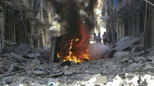 Syrians inspect damaged buildings after airstrikes by government helicopters on the rebel-held Aleppo neighborhood of Mashhad on Tuesday. A year of bombing in Syria stirs little debate among Russians