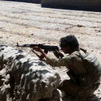 An Afghan soldier patrols during on going fighting with Taliban in the Tarin Kot district of Uruzgan province on Thursday. The Taliban stormed into Tarin Kot, triggering heavy fighting around government buildings as panicked residents scrambled to flee the capital of southern Uruzgan province. Hundreds of Taliban storm south Afghan city, sparking panic before being repelled