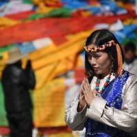 A Chinese tourist in traditional Tibetan clothes poses for a picture outside the Jokhang Temple — the most sacred in Tibetan Buddhism — in Lhasa, the capital of China's Tibet Autonomous Region, on Sept. 10. In Tibet, Chinese characteristics set tone of religious freedom