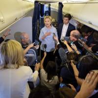 Democratic presidential nominee Hillary Clinton speaks to the press onboard her plane Monday above Iowa. Clinton faces press, blasts Russia meddling in U.S. polls as Trump again softens on immigration