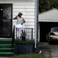 A resident gives the thumbs down as the motorcade carrying Republican presidential nominee Donald Trump passes through the city of Flint, Michigan, Wednesday. Trump hands Oz one-page summary of physical before uninvited Flint visit