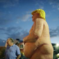 People look at a statue of a naked Republican U.S. presidential candidate Donald Trump in Las Vegas on Wednesday. The statue was knocked down and sprayed with graffiti, and removed Friday. Police search for culprits after naked Donald Trump statue is stolen in Miami