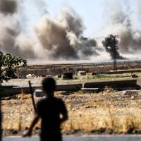 This picture taken Thursday in the Turkish-Syrian border town of Karkamis, in the southern region of Gaziantep, shows a boy looking at smoke rising close to the Syrian-Turkish border town of Jarabulus. Turkey denied a U.S. claim it had agreed a truce with a Kurdish militia targeted as part of its week-old intervention in Syria but Turkish-backed fighters confirmed a lull in the fighting. Turkey claims gains against Islamic State in Syria, says Kurds didn't retreat east of Euphrates