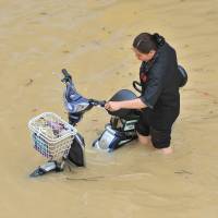 A woman wades through a flooded street in Fuzhou after Typhoon Meranti made landfall in southeastern China on Thursday. Death toll rises to 15 after typhoon lashes China, Taiwan