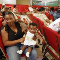 Haitian national Carole Manigat holds her daughter as she waits for her turn to fill out temporary protective status papers at Notre Dame d'Haiti Catholic Church in the Little Haiti neighborhood in Miami in this file photo from Jan. 21, 2010. The U.S. Department of Homeland Security said Thursday that it was widening efforts to deport Haitians, a response to thousands of immigrants from the Caribbean nation who have overwhelmed California border crossings with Mexico in recent months. U.S. toughens stance on Haitians seeking entry from Brazil