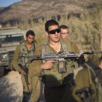 Israeli soldiers secure a road leading to where projectiles fired from Syria hit the Israeli-controlled part of the Golan Heights on Tuesday. U.S., Israel to sign record military aid deal