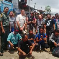 Foreign and local tourists pose Wednesday for photographs with park rangers as they evacuate near the Barujari volcano in the Gunung Rinjani National Park. Hundreds of tourists have fled a volcanic eruption, but expressed fears some may have stayed behind to document the natural wonder. Indonesia rescuers help climbers evacuate off erupting volcano