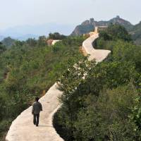 A villager walks along a restored section of the Great Wall in Suizhong County in northeastern China's Liaoning Province on Wednesday. Famed section of Great Wall of China marred by 'ugly repair job'