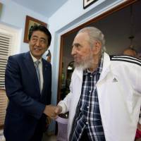 Former Cuban President Fidel Castro shakes hands with Prime Minister Shinzo Abe during a meeting in Havana on Thursday. Abe, Fidel Castro agree to a world without nuclear weapons