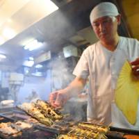 A cook charcoal broils eels on Monday at Miyagawa Honten, a venerable Tokyo eatery that specializes in the fish. CITES considers tighter monitoring of trade in eels