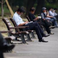 Workers rest on park benches in Tokyo in May. Two aides to Prime Minister Shinzo Abe said the nation is planning to bring in more overseas workers to bolster the shrinking labor force. Japan grows more open to foreign workers as population declines