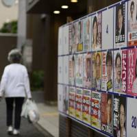 A woman walks past posters of candidates for July's Upper House election in Tokyo. New website to help track Diet members' money trails