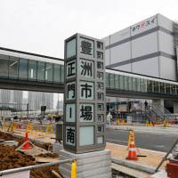 A sign reading Tokyo Metropolitan Central Wholesale Market, Toyosu Market, main gate — south stands at the construction site in the Toyosu district on Monday. Tokyo's safety claims for Toyosu fish market cleanup getting harder to sell