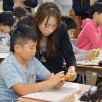 Pupils at the Kitagata Elementary School in Takeo, Saga Prefecture, use tablet computers in class in December 2015. Japan's schools embracing tablets but inadequate support and security remain concerns