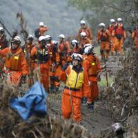 Rescue workers continue their search for missing people Thursday in typhoon-hit Iwaizumi, Iwate Prefecture. Four August typhoons will be designated as severe disasters