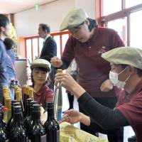 Staff at Komaki Winery in Komaki, Aichi Prefecture, sell wine made by people with disabilities in April. Aichi winery helps mentally disabled make a living