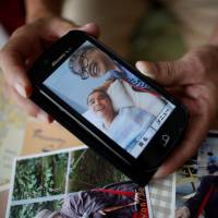 Survivor: Takashi Ono shows a recent photo of his wife, Chikiko, and stepson, Kazuya, a resident of the Tsukui Yamayuri En facility in Sagamihara. Kazuya is recovering from multiple stab wounds that left him in critical condition after the attack at the home for people with disabilities in July. Sagamihara massacre begs question: Do we want a society that only values usefulness?