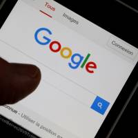 The future?: A man holds his smartphone, open to Google’s home page. Google Deepmind’s AlphaGo computer program achieved a historic win over go master Lee Sedol earlier this year, causing some observers to reflect on the future of machine sentience. Building a stairway to the singularity
