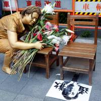 A continuing struggle: In Taipei, a local protester poses as a bronze statue of a “comfort woman” next to a picture of Japanese Prime Minister Shinzo Abe with Chinese characters reading “apology.” A museum devoted to the comfort women issue will open in Taipei in September. Complicating Taiwan's love affair with Japan