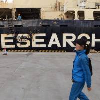 Unchecked: A woman walks by the Nisshin Maru whaling ship in Tokyo in 2011. Did Japan fudge the truth about whaling?
