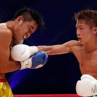 Naoya Inoue (right) lands a punch on Thailand's Petchbarngborn Kokietgym during their WBO super flyweight title fight in Zama, Kanagawa Prefecture, on Sunday. Inoue defends WBO superfly title with TKO