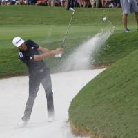 Dustin Johnson hits out of a bunker on the 18th hole on Saturday in Atlanta. Johnson tied for lead in Tour Championship
