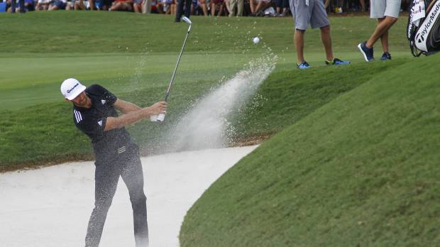 Dustin Johnson hits out of a bunker on the 18th hole on Saturday in Atlanta. Johnson tied for lead in Tour Championship