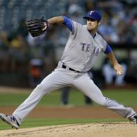 Texas starter Cole Hamels pitches against Oakland in the first inning on Friday night. Rangers clinch AL West title