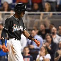 Miami's Dee Gordon weeps as he returns to the dugout after hitting a solo home run in the first inning against New York on Monday night. The Marlins beat the Mets 7-3. Marlins win one for Fernandez